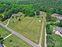 Expansive, green acreage featuring multiple homes, manicured lawns, and lush tree coverage, surrounded by peaceful roads at 11850 Sugar Hill Rd, Davidson, NC 28036