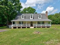 Charming ranch-style home with a spacious front porch and well-maintained lawn at 11850 Sugar Hill Rd, Davidson, NC 28036