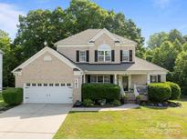 Charming two-story brick home with a well-manicured lawn and a welcoming front porch at 161 Dairy Farm Rd, Mooresville, NC 28115