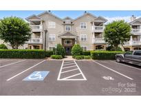 Inviting condo building with well-maintained landscaping, parking, and balconies on a sunny day at 17111 Doe Valley Ct, Cornelius, NC 28031