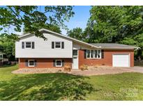 Charming split-level home featuring a brick facade and white siding, complemented by a well-manicured lawn at 1822 N New Hope Rd, Gastonia, NC 28054