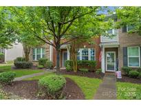 Inviting brick townhome with a landscaped front yard and walkway leading to the entrance at 18460 W Catawba Ave, Cornelius, NC 28031