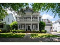 Charming two-story home featuring double porches, a well-manicured lawn, and lush landscaping at 189 Mills Ln, Fort Mill, SC 29708