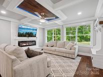 Bright living room with fireplace, large windows, and coffered ceiling with modern ceiling fan at 195 Bluebird Ln, Salisbury, NC 28146