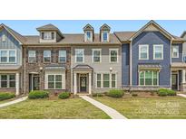 Charming townhome with a mix of brick and siding, complemented by a well-manicured lawn and inviting walkway at 19812 Elise Caroline Aly, Davidson, NC 28036