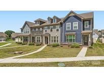 Charming townhomes showcase varied exteriors and landscaping, creating inviting curb appeal on a sunny day at 19812 Elise Caroline Aly, Davidson, NC 28036
