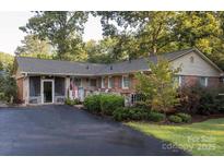 Charming brick home featuring well-maintained landscaping, a spacious driveway, and a welcoming screened entrance at 211 General Stonewall Jackson Dr, Stanley, NC 28164