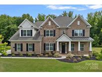 Stunning brick home featuring manicured lawn, elegant black shutters, and impeccable landscaping at 2185 Loire Valley Dr, Fort Mill, SC 29707
