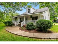 Charming two-story home with a welcoming front porch, lush landscaping, and a curved sidewalk at 2315 Lanesboro Rd, Marshville, NC 28103