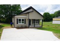 Charming single-story home with tan siding, black accents, and a new concrete driveway at 256 Lincoln Sw St # 1, Concord, NC 28025