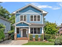 Charming two-story blue home featuring a welcoming front porch, well-manicured lawn, and classic architectural details at 331 Solomon St, Charlotte, NC 28216