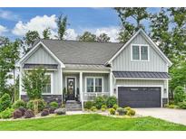 Charming single-Gathering home with manicured lawn, attached garage, and inviting front porch and lovely landscaping at 562 Preservation Dr, Fort Mill, SC 29715