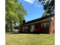 Charming single-story brick home with a well-manicured lawn and a bright blue sky overhead at 610 E Maryland Ave, Bessemer City, NC 28016