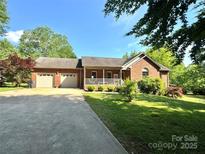 Charming single-story brick home with a well-maintained front lawn and attached two-car garage at 675 Godbey Rd, Salisbury, NC 28147