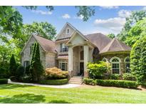 Stunning two-story brick home with a manicured lawn and lush landscaping creates great curb appeal at 6795 Montgomery Rd, Lake Wylie, SC 29710