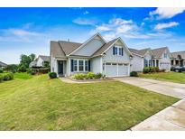 Charming single-Gathering home showcasing well-maintained landscaping, blue shutters, and an attached two-car garage at 7362 Overjoyed Xing, Charlotte, NC 28215