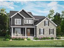 Beautiful two-story home with a stone and dark siding exterior, and a well-maintained lawn and colorful flowers at 7513 Lancaster Hwy # 6, Waxhaw, NC 28173