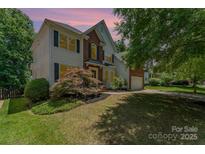 Charming two-story home features a blend of brick and siding, complemented by well-manicured landscaping and mature trees at 1147 Anduin Falls Dr, Charlotte, NC 28269