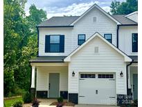 Charming two-story home with a white exterior, attached garage and well-manicured landscaping at 11619 Sapsucker Ln # 65, Charlotte, NC 28215