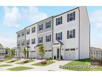 Charming townhome showcasing a two-story design, individual garages, and a well-manicured front lawn at 11716 Avocet Dr # 75, Charlotte, NC 28215
