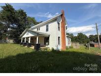 Two-story home with white siding, a covered front porch and a brick chimney at 1445 33Rd Sw St, Hickory, NC 28602