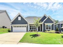 Charming home showcasing well-maintained lawn, blue siding, and inviting two-car garage at 163 Crenshaw Nw Pl, Concord, NC 28027