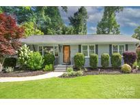 Charming single-story home featuring manicured landscaping, gray brick accents and a cozy front porch at 1715 Wensley Dr, Charlotte, NC 28210