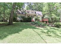 Charming two-story home featuring a lush green lawn, mature trees, and a cozy deck at 173 Rocky River Rd, Mooresville, NC 28115