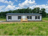Charming single-story home with gray siding, black shutters, and a welcoming front porch in a serene setting at 188 Trivette Rd, Harmony, NC 28634