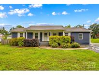 Charming single story home with well-maintained landscaping, blue siding, and white trim at 211 Ridgecrest St, Kannapolis, NC 28081