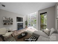 Bright living room featuring a fireplace, shelving, and large windows offering plenty of natural light at 415 W 7Th St # H, Charlotte, NC 28202