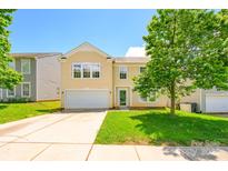 Charming two-story home featuring a lush front yard and attached garage, perfect for suburban living at 4521 Palustris Ct, Charlotte, NC 28269
