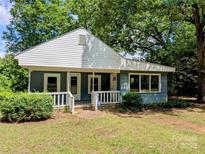 Charming single-story home featuring a covered front porch, light blue siding, and surrounded by mature trees at 647 Mckay Hill Rd, Mount Gilead, NC 27306