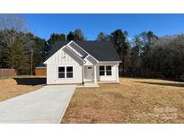 Charming new construction features white siding and a welcoming front porch and a concrete driveway at 6756 Denver Heights Cir, Denver, NC 28037