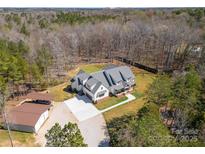 Expansive aerial view of a modern farmhouse-style home with a large yard, surrounded by dense trees at 722 Clegg Farm Dr, York, SC 29745