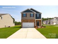 Two-story home boasts a manicured lawn, brick accents, and a two-car garage, embodying suburban charm at 1044 Horizon Ln, Chester, SC 29706