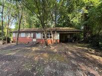 View of home's front exterior with brick accent, covered porch, and mature trees at 112 Greenwood Ave, Belmont, NC 28012