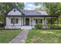 Charming home featuring a covered front porch, fresh landscaping, and light exterior at 118 Cabarrus W Ave, Concord, NC 28025