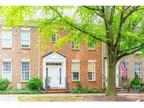 Charming brick townhome featuring a classic design with a well-manicured front yard and mature tree at 123 Singleton Rd, Mooresville, NC 28117