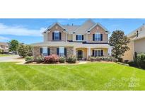 Charming two-story home featuring a beautifully manicured lawn and stone-accented facade at 1618 Bay Meadows Nw Ave, Concord, NC 28027