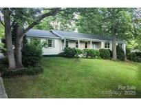 Charming one-story home featuring a well-manicured lawn, lush greenery, and a welcoming front porch at 1770 Windsor Dr, Lancaster, SC 29720