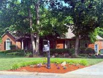 Charming brick home with a beautifully landscaped front yard featuring lush greenery and vibrant flower beds at 208 Stone Ridge Dr, Salisbury, NC 28146