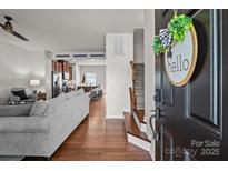 Inviting open-concept living room boasts wood floors, flowing into a modern kitchen with stainless steel appliances at 2444 Mariners Cove Ln, Denver, NC 28037