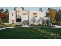 Modern home with a manicured lawn, large windows, stone accents, and a unique architectural design at 2861 Sharon Rd # 1, Charlotte, NC 28211