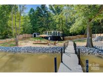Charming waterfront home with a private dock, deck, and lush, mature trees at 295 Rendleman Rd, Salisbury, NC 28146