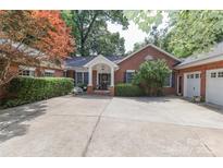 Charming single-story red brick home with a welcoming front porch and well-manicured landscaping at 625 Saint Andrews Rd, Statesville, NC 28625