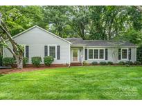 Charming single-story home with a lush green lawn and mature trees at 6749 Windyrush Rd, Charlotte, NC 28226
