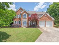 Two-story brick home featuring a well-manicured lawn and a two-car garage at 9710 Holden Ct, Charlotte, NC 28277