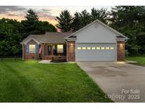 Charming brick home with a two-car garage and manicured lawn at sunset at 112 Chasse Ct, Cleveland, NC 27013