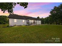 Charming single-story home with well-manicured lawn and inviting curb appeal under a colorful sunset sky at 130 Johnson Dairy Rd, Rockwell, NC 28138